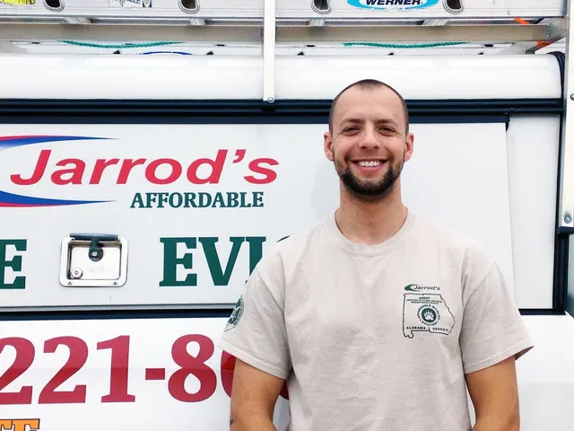 A Jarrod's wildlife technician beside an Affordable Wildlife Eviction truck
